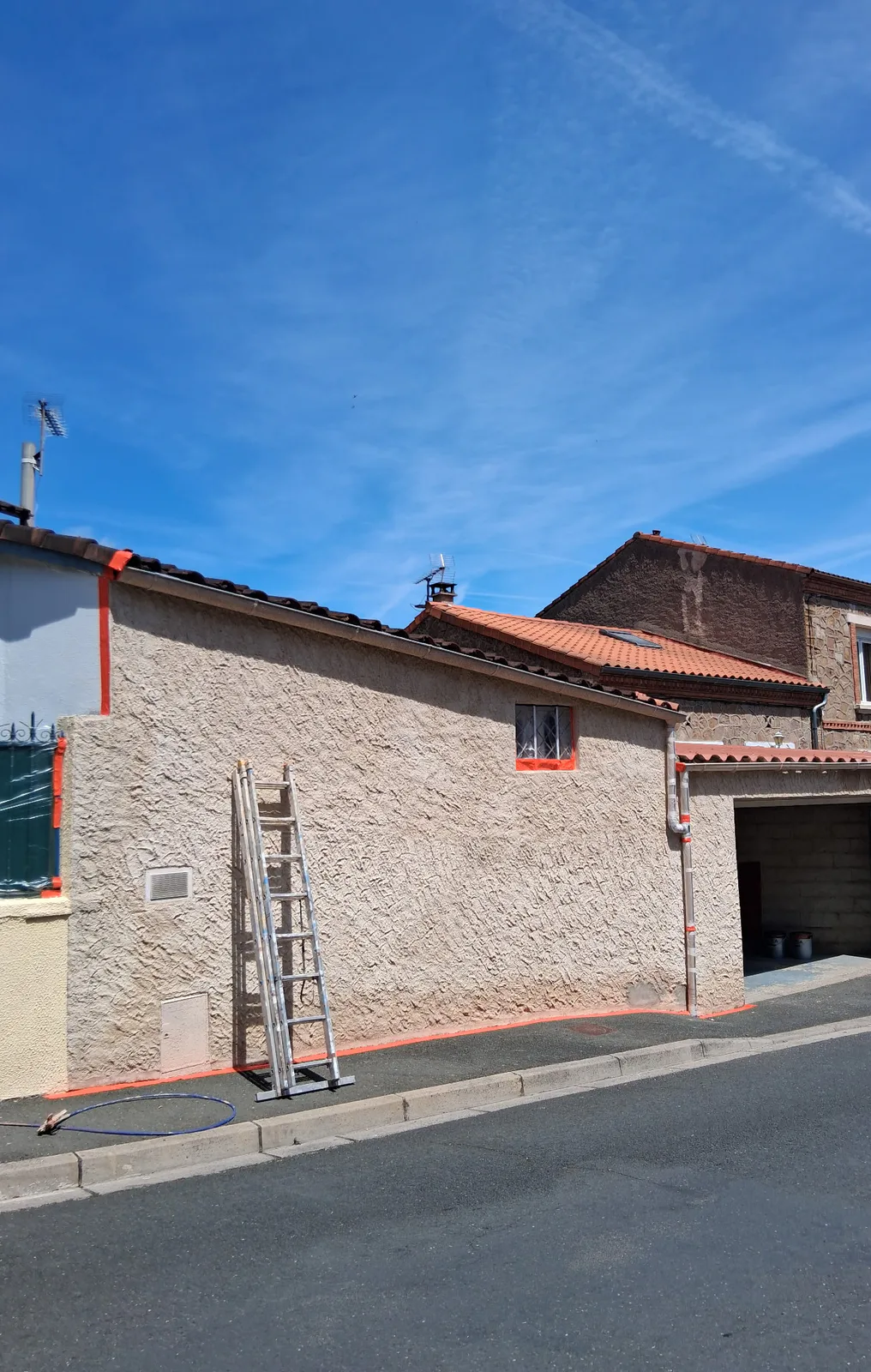 Façade de garage en cours de préparation avant ravalement à Carmaux